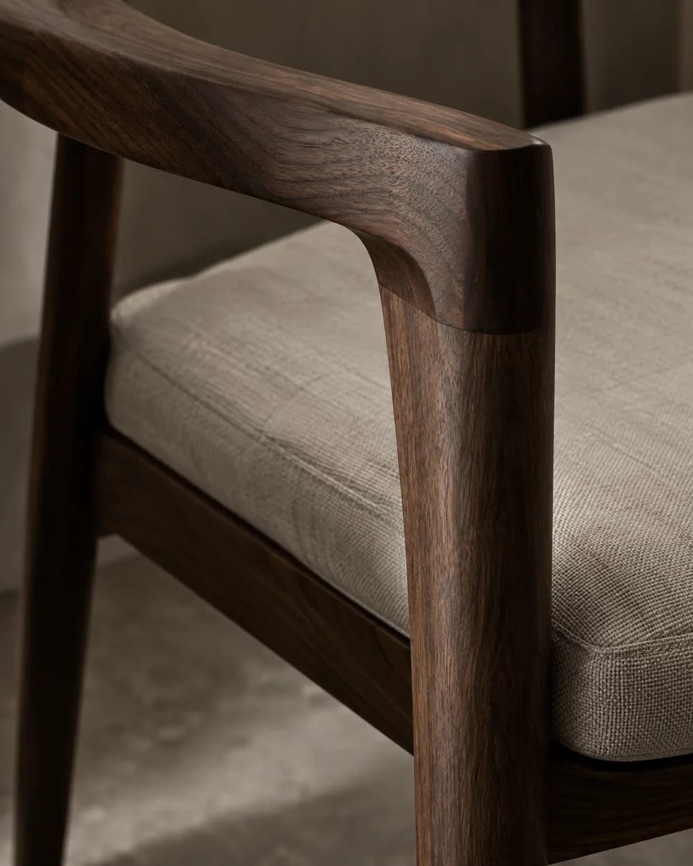Concept study of a curved wooden chair joint beside a woven upholstery cushion.
